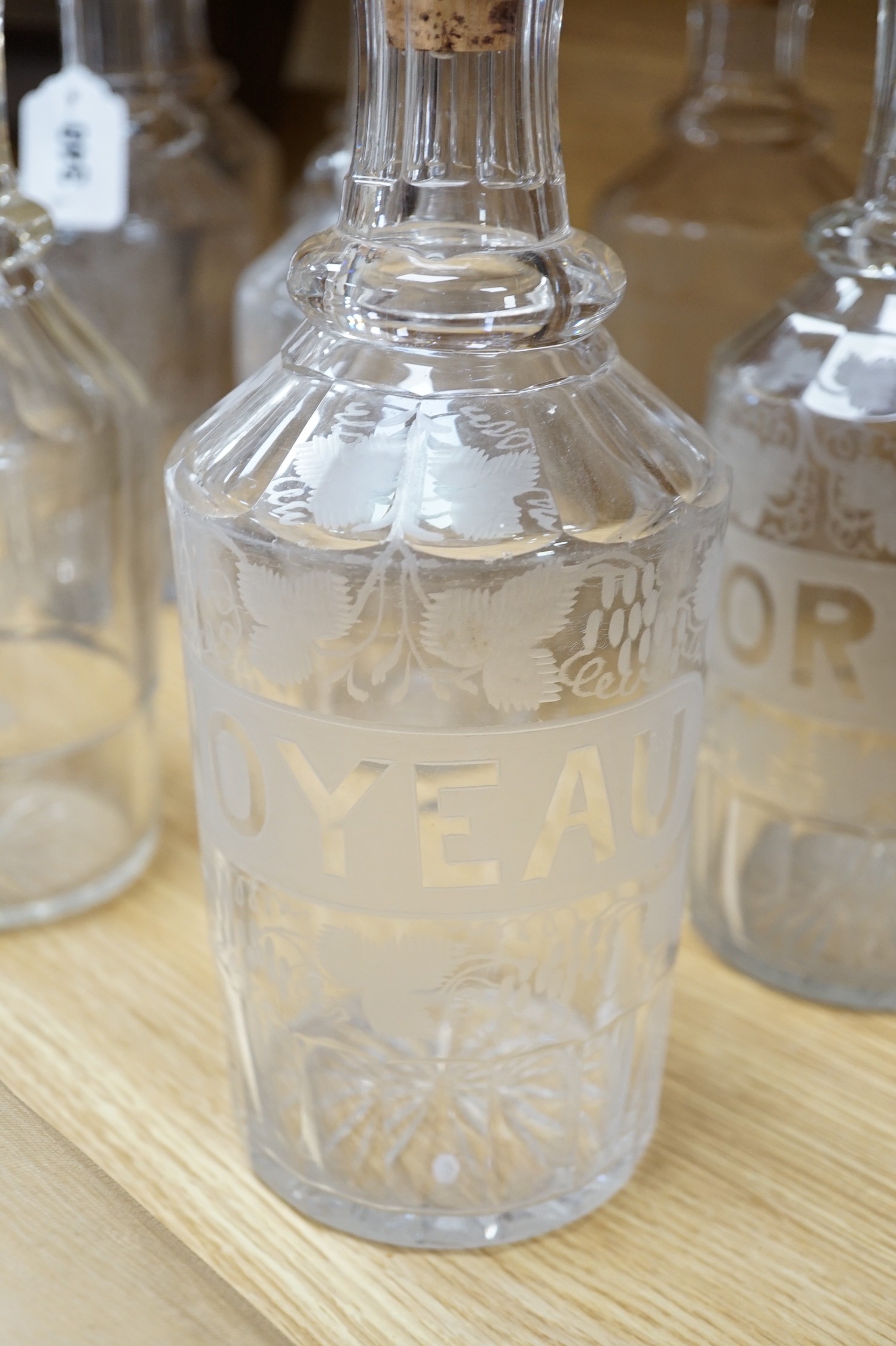 A set of 13 Victorian etched and named glass decanters; 27 cm.